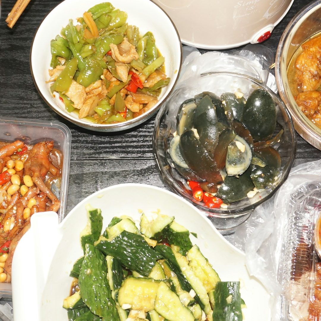 Mesa lista para comer en una familia China, con ensalada de pepinillo, berenjena y otros vegetales
